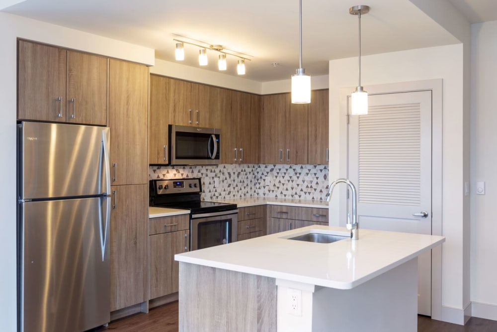 Quartz countertops and stainless-steel appliances in a model apartment's kitchen at ArLo Apartments in Portland, Oregon