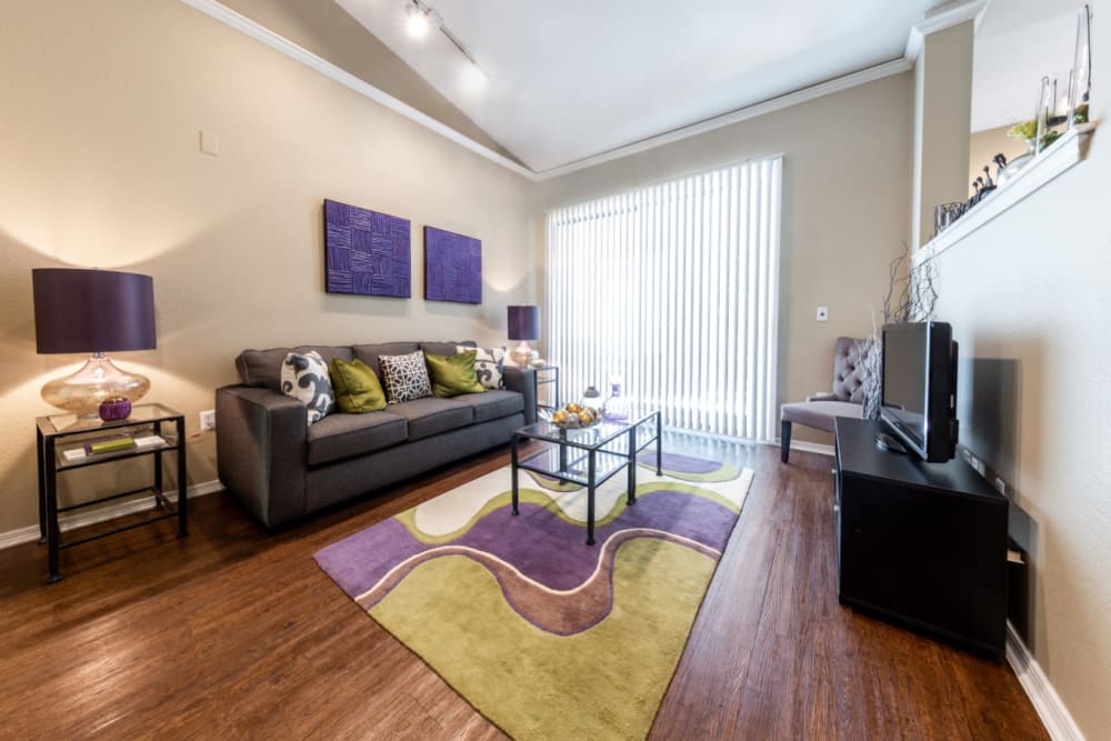 Bright and open living room with vaulted ceilings and wood flooring at Marquis at Waterview in Richardson, Texas