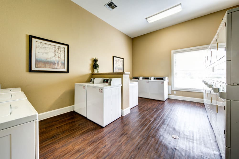 Community laundry area with coin-operated washers and dryers at Marquis at Silver Oaks in Grapevine, Texas