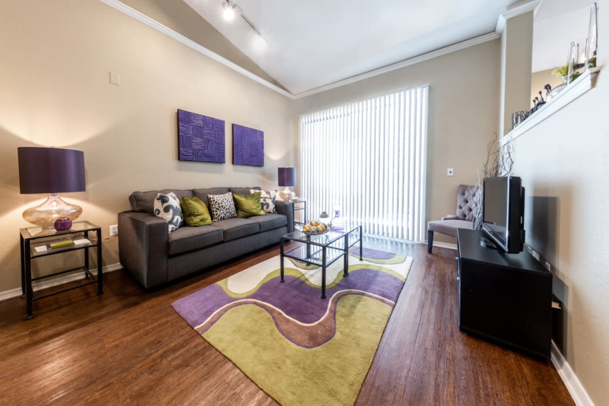 Bright and open living room with vaulted ceilings and wood flooring at Marquis at Waterview in Richardson, Texas