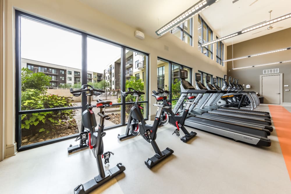 Spin bikes and treadmills facing window in fitness room at Marq Uptown in Austin, Texas