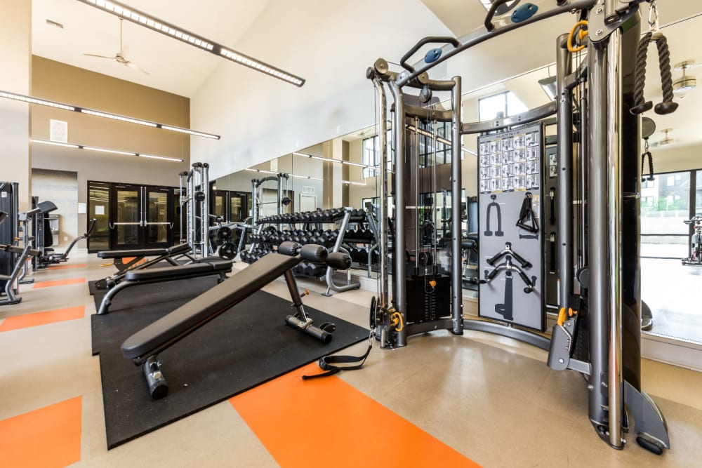 Assisted weight machine and weight benches in fitness room at Marq Uptown in Austin, Texas