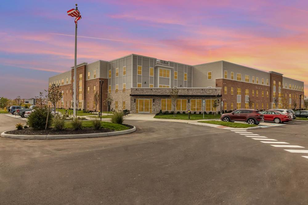 Modern apartment community with landscaped entrance and bright exterior, surrounded by parking and trees at Haven Crossing in Walton, Kentucky