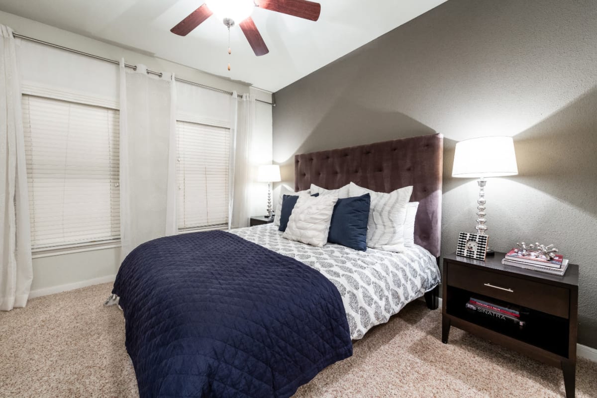 Spacious carpeted bedroom with multiple windows at Marquis at the Reserve in Katy, Texas