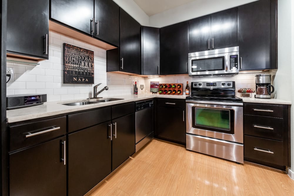 Modern style kitchen with stainless steel appliances at Marquis at the Reserve in Katy, Texas