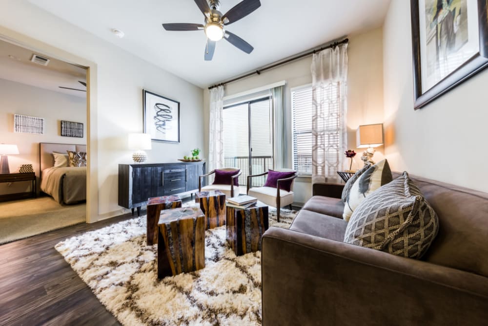 Spacious living room modernly decorated with access to private balcony at Marq Uptown in Austin, Texas