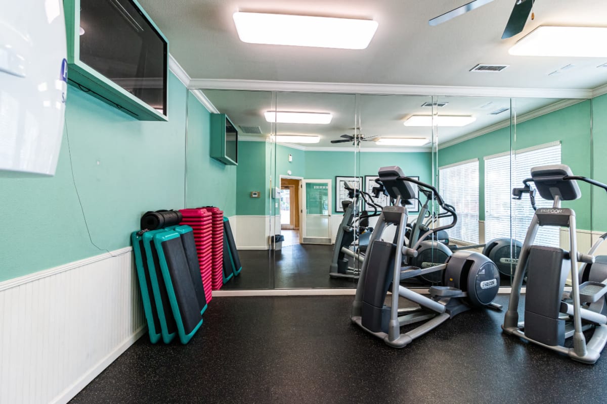 Elliptical machines facing television monitor in fitness room at Marquis of Carmel Valley in Charlotte, North Carolina