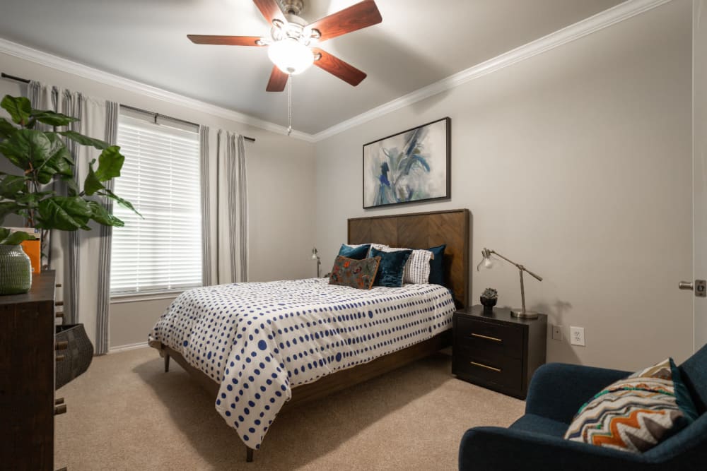 Carpeted bedroom with ceiling fan at Marquis at Bellaire Ranch in Fort Worth, Texas