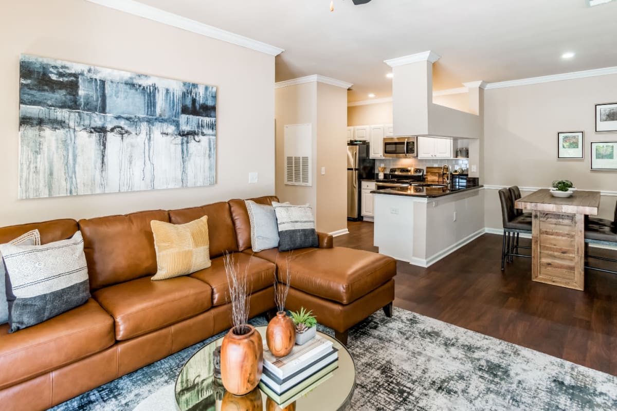 Spacious living area with modest dining area and wood flooring at Marquis at Carmel Commons in Charlotte, North Carolina