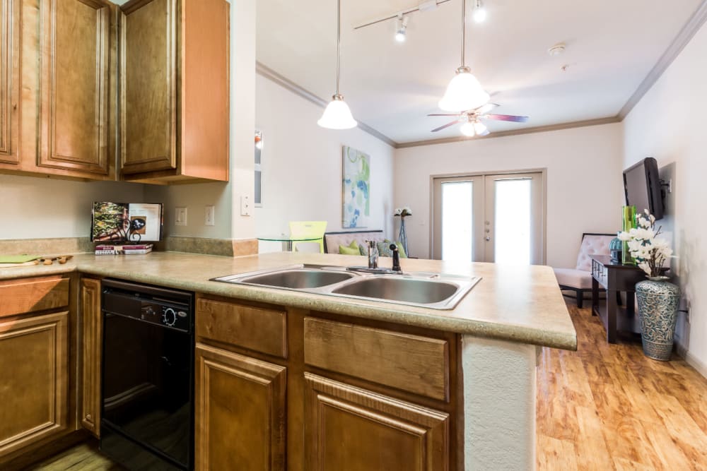 Bright kitchen with wood flooring facing living area at Marquis at Clear Lake in Webster, Texas
