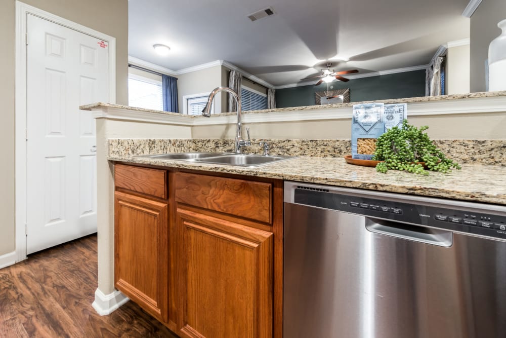 Modern style kitchen with stainless steel appliances, granite countertops, and wood flooring at Marquis at The Cascades in Tyler, Texas