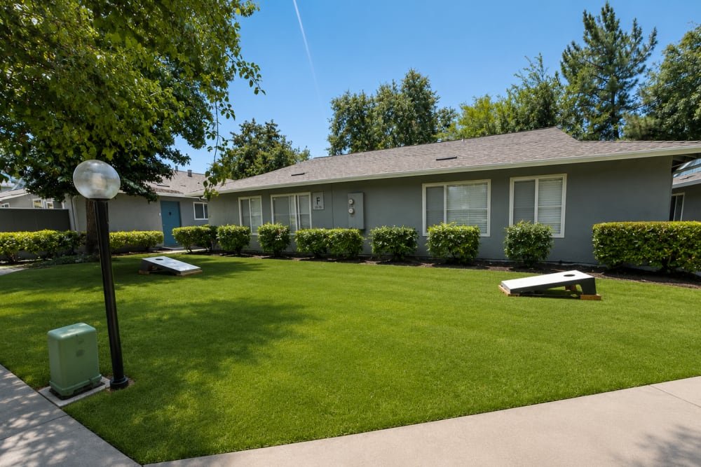 Apartment exterior with green lawn and walkway at The Everette in Rocklin, California