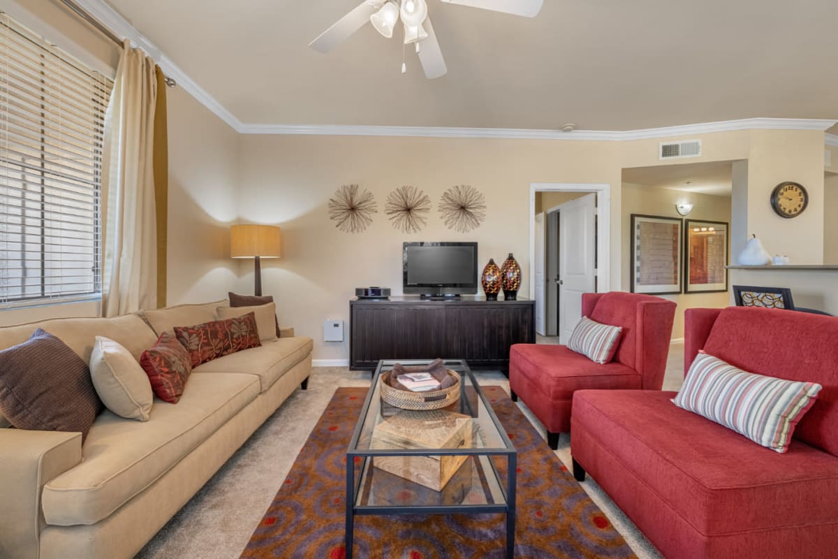 Carpeted living room with earth tone style furniture at Marquis at Sonoran Preserve in Phoenix, Arizona
