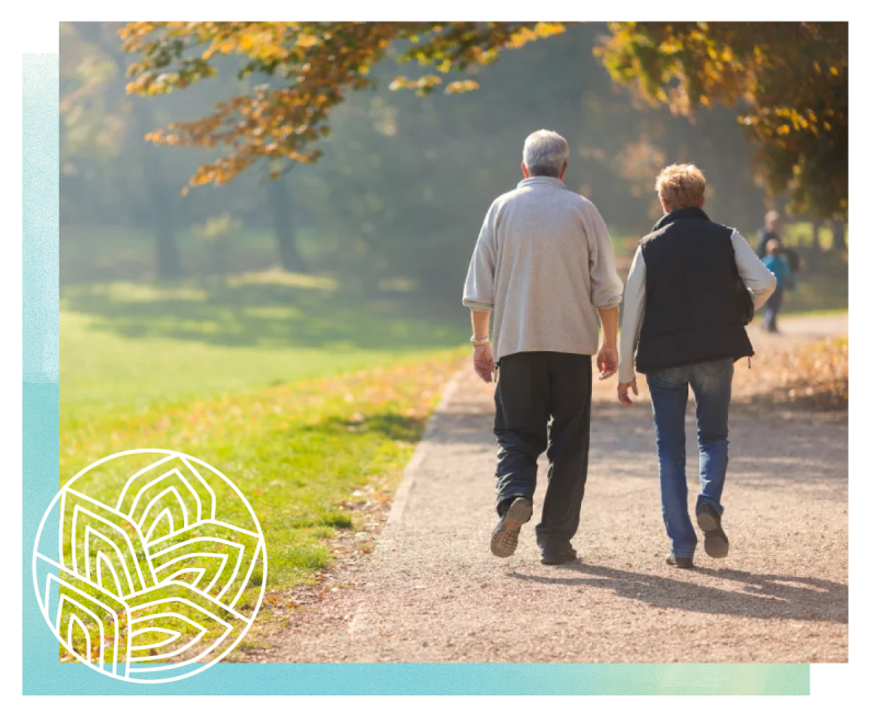 Resident couple walking down a dirt path at a MBK Senior Living community