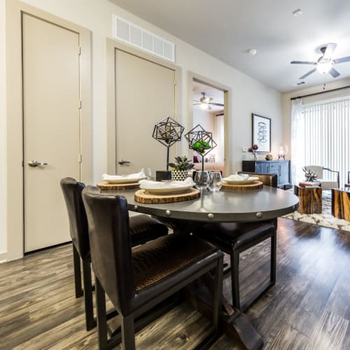 Dining table on wood flooring overlooking living room area at Marq Uptown in Austin, Texas