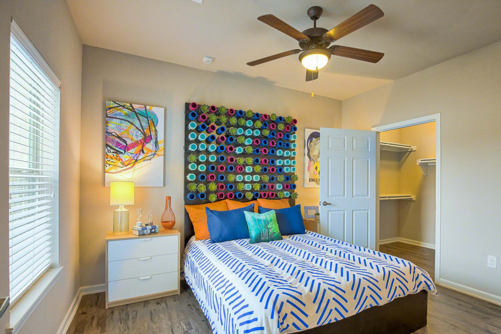 Spacious model bedroom with walk in closet and ceiling fan at Creekside at Kenney's Fort in Round Rock, Texas