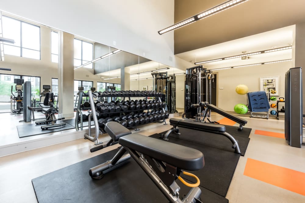 Free weights and benches with large mirror in fitness room at Marq Uptown in Austin, Texas
