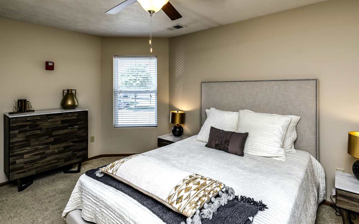 Bedroom with large bed and ceiling fan at The Falgrove Apartments in Omaha, Nebraska