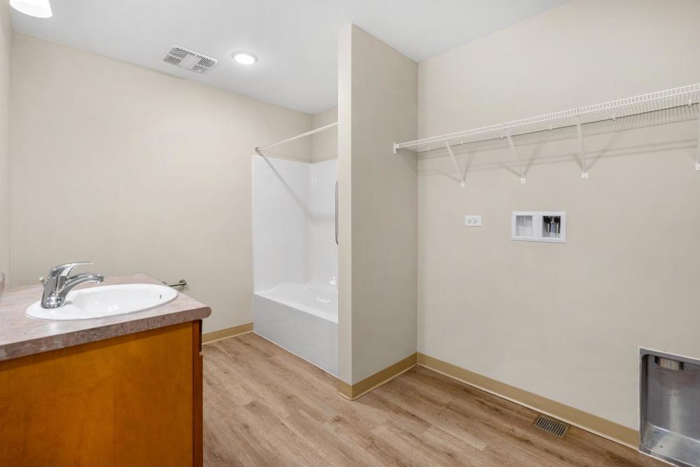 Bathroom with washer and dryer hookups and vanity sink at Deville Manor in Oswego, Illinois