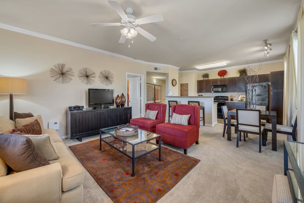 Bright and cheerful living area with carpet and ceiling fan at Marquis at Sonoran Preserve in Phoenix, Arizona