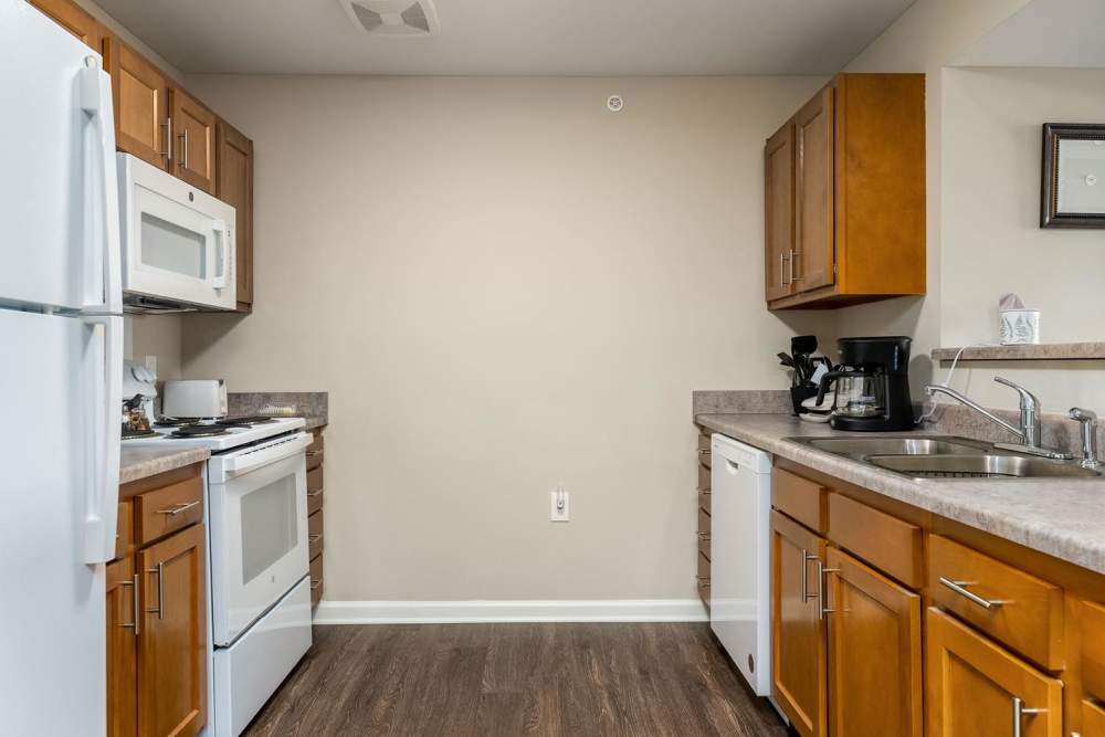 Modern kitchen with granite countertops, stainless steel appliances, and wood-style flooring at Labelle Greene IV in Wheeling, West Virginia