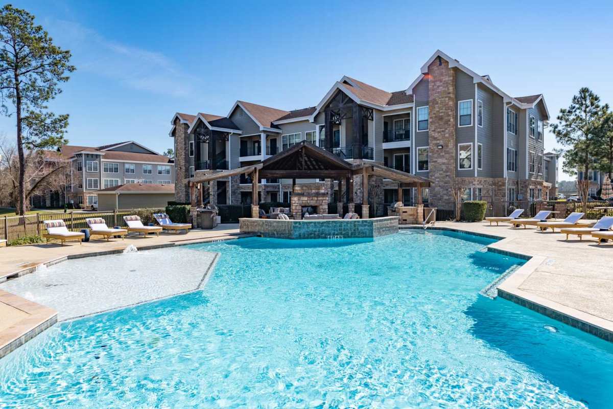 Exterior view of apartment with a pool area at Villas at Valley Ranch in Porter, Texas