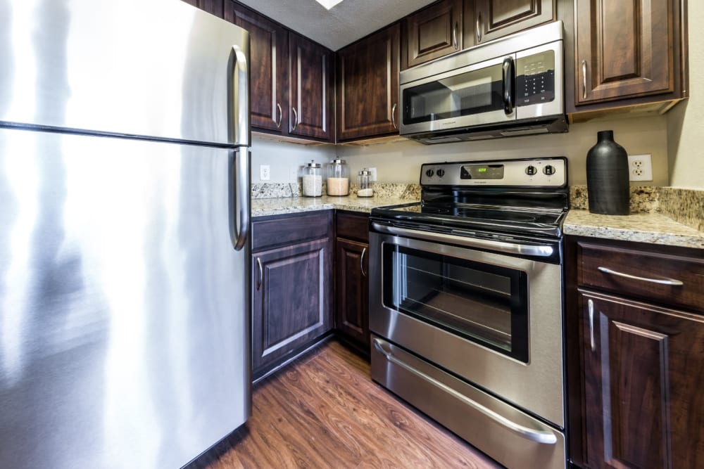 Modern kitchen with stainless steel appliances and granite counter tops at Marquis at Stonegate in Fort Worth, Texas