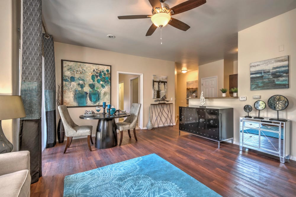 Dining room and living room with wood-style flooring at Promenade at Hunter's Glen Apartments in Thornton, Colorado