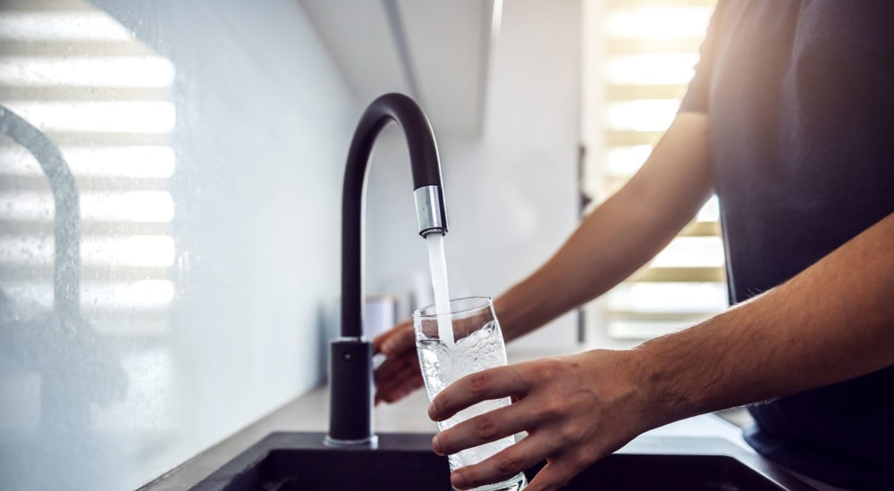 Person filling up water glass at kitchen sink at Pacific Palms in Stockton, California