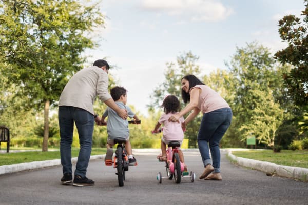 Parents pushing their kids on bikes at a park near Forest Edge Townhomes in Raleigh, North Carolina