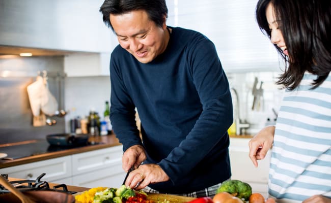 Couple chopping vegetables in their fully equipped kitchen at The Village at Cliffdale Apartment Homes in Fayetteville, North Carolina