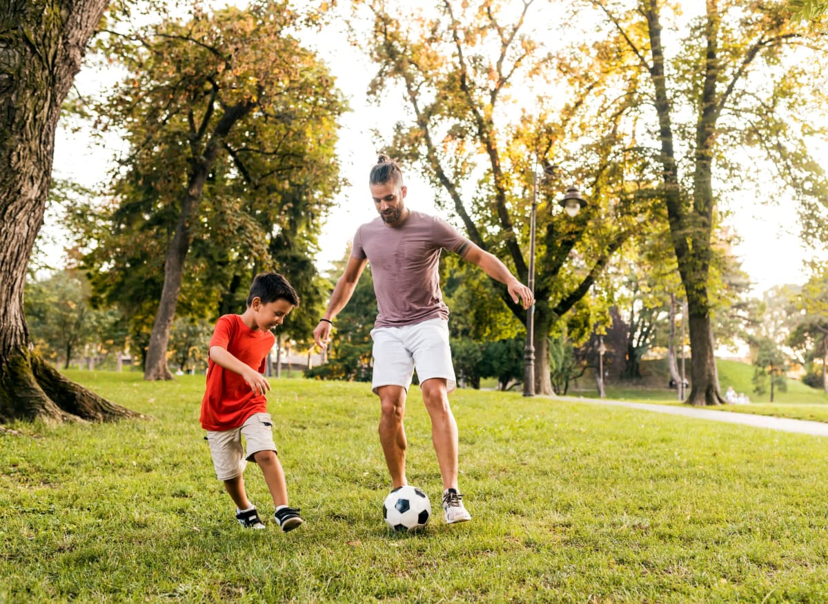 Family playing soccer at Clifton Ridge Apartments in Louisville, Kentucky