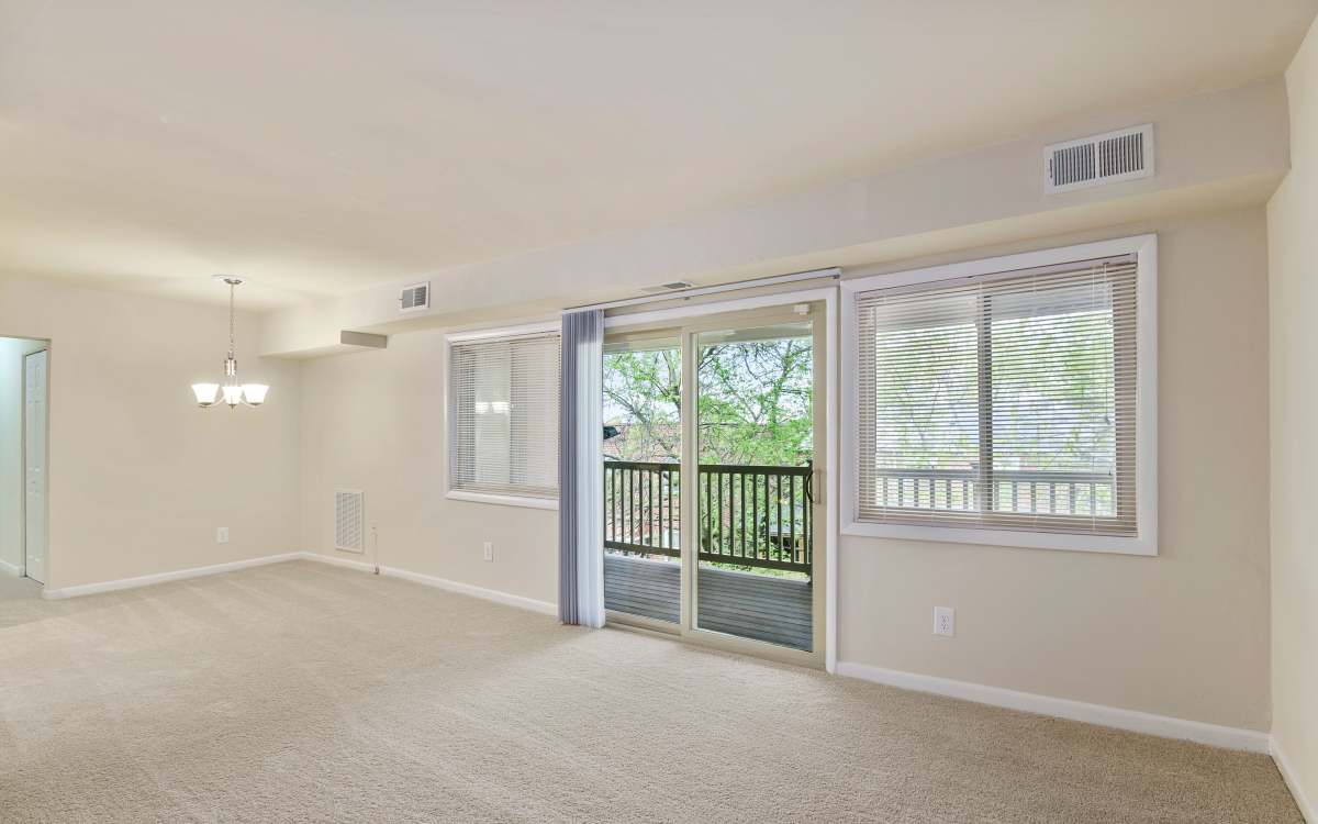 Unfurnished living room with attached patio at Cross Creek in Laurel, Maryland