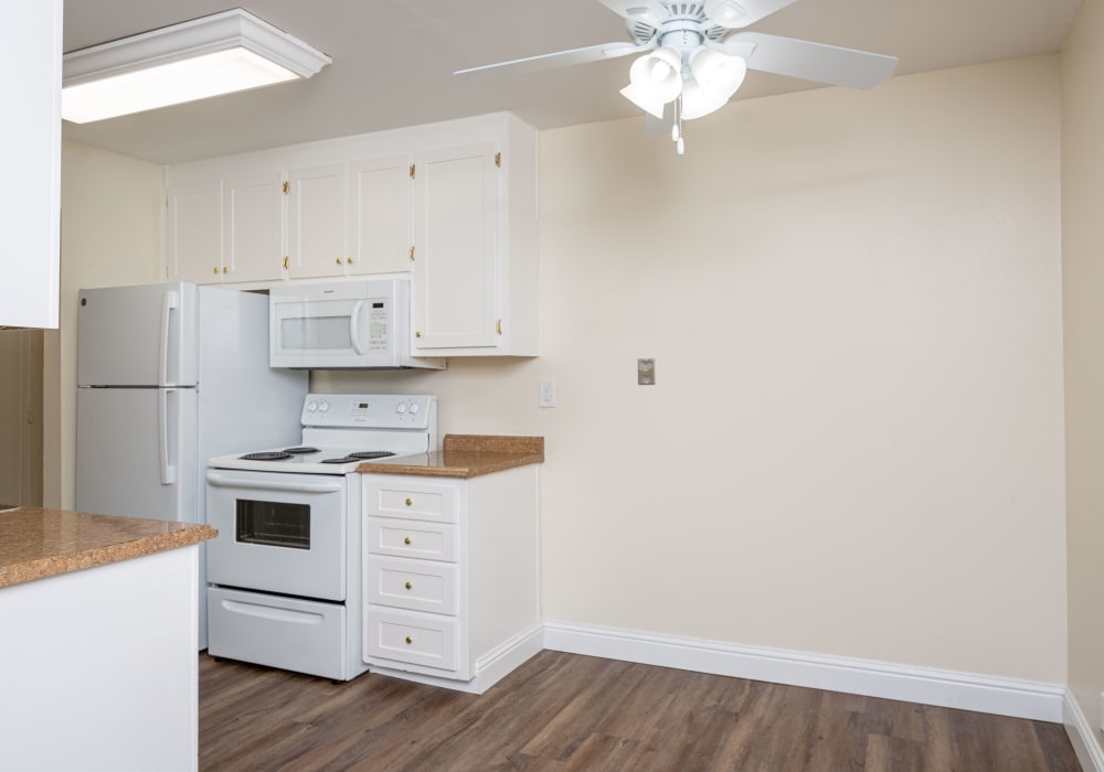 Kitchen with wood floors and a ceiling fan at Bayfair Apartments in San Lorenzo, California