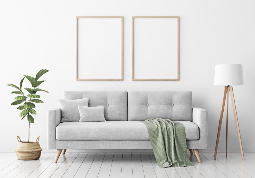 Modern living rooms with a mid-century style gray couch, an indoor tree, and tall lamp at Everwood at The Avenue in Murfreesboro, Tennessee