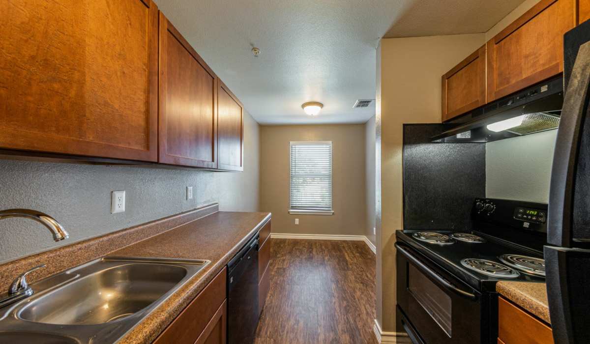 Modern kitchen with wooden cabinets at Palatia Apartment Homes in San Antonio, Texas