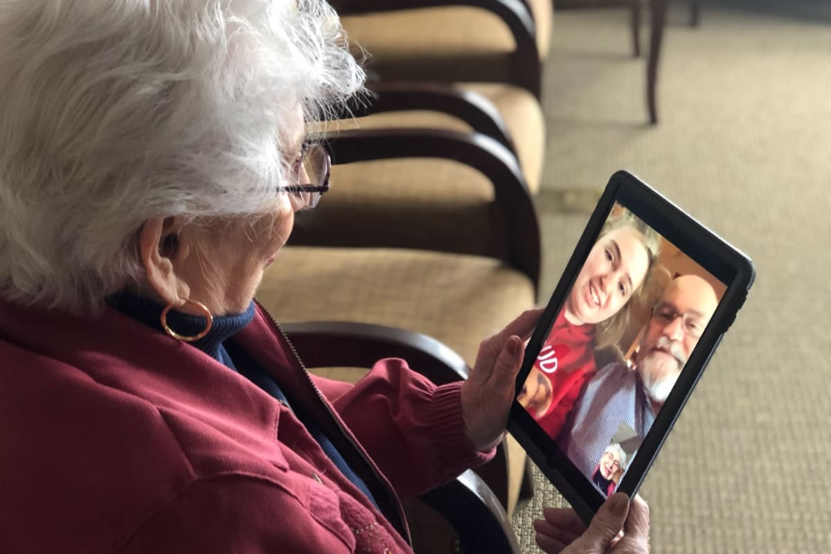 A resident using a tablet to communicate with her family safely at Oxford Senior Living in Wichita, Kansas