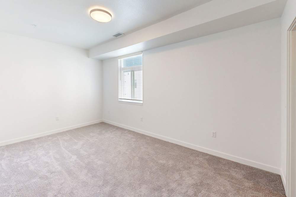 Apartment bedroom with carpet flooring and a window at The Rose on Colfax in Denver,Colorado