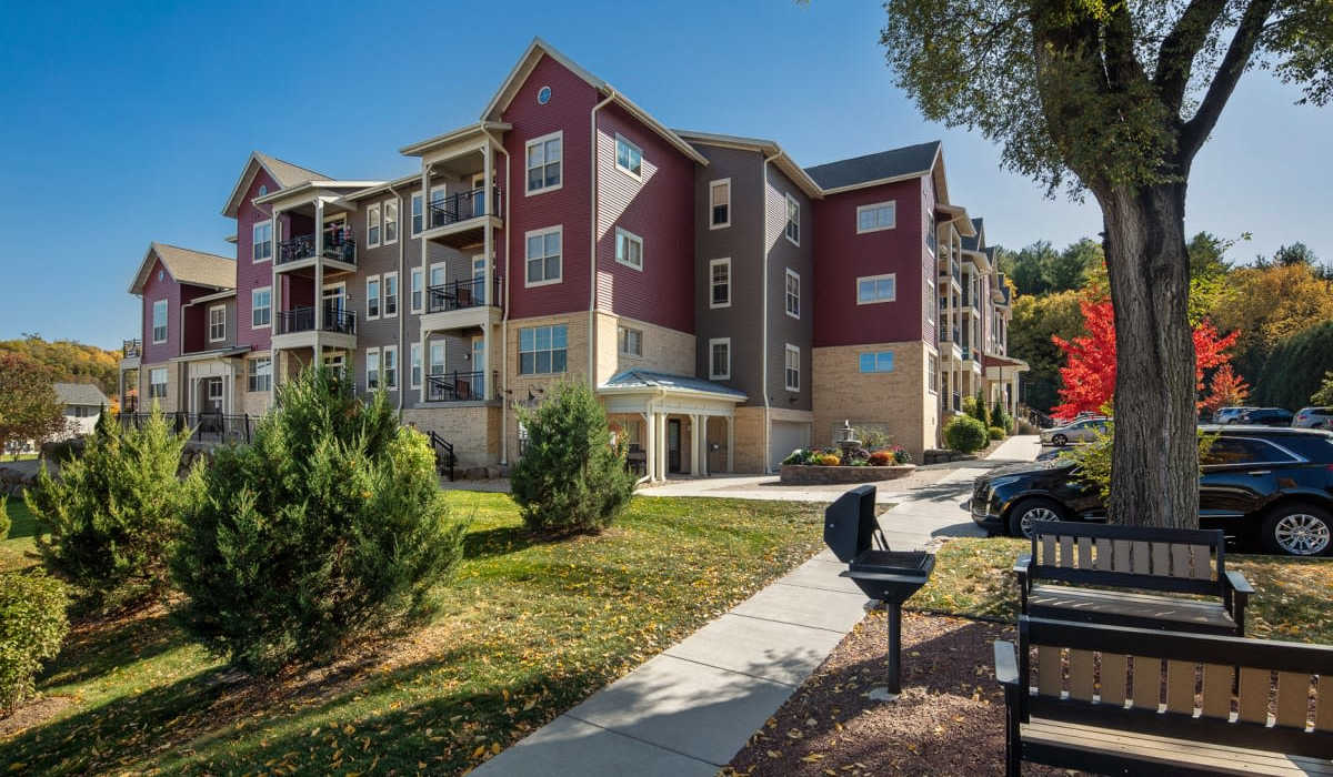 Exterior shot of apartments with grilling area and off street parking at Mill Creek Apartments in Cross Plains, Wisconsin