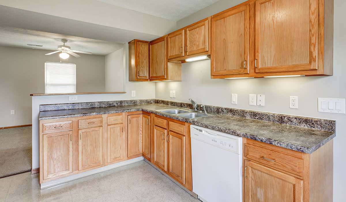 Kitchen with white appliances including dishwasher at Olde Hickory in Coshocton, Ohio