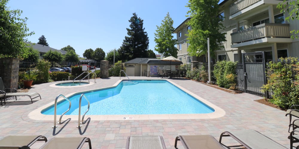 Outdoor swimming pool and hot tub at Summerhill Terrace Apartments in San Leandro, California