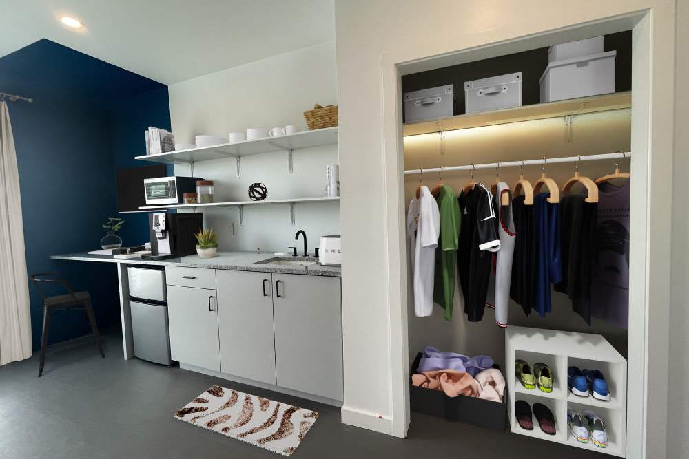 Walk-in closet with shelf, kitchen and built-in desk of a studio apartment at Martin Flats in Nashville, Tennessee