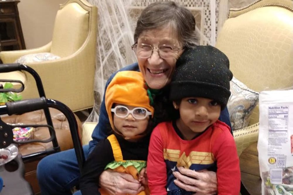 A resident holding her grandchildren at Inspired Living Sugar Land in Sugar Land, Texas