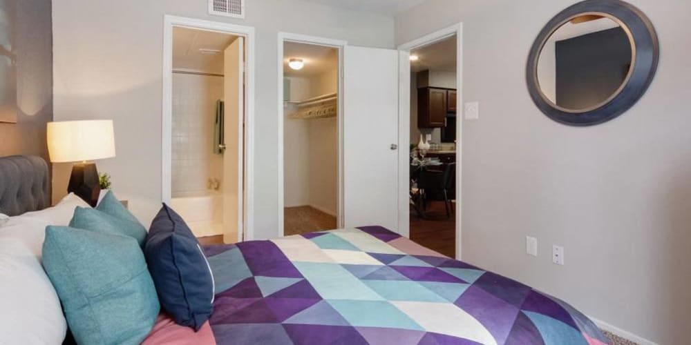 Well lit model bedroom with bathroom and closet connected at Vantage Point in Houston, Texas