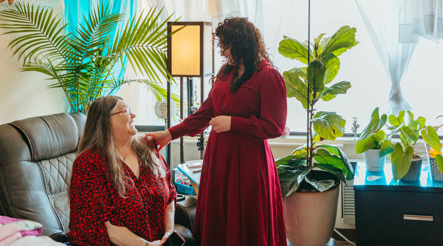 Resident relaxing in her private room and talking with the community director at Cascade Park Vista Assisted Living in Tacoma, Washington