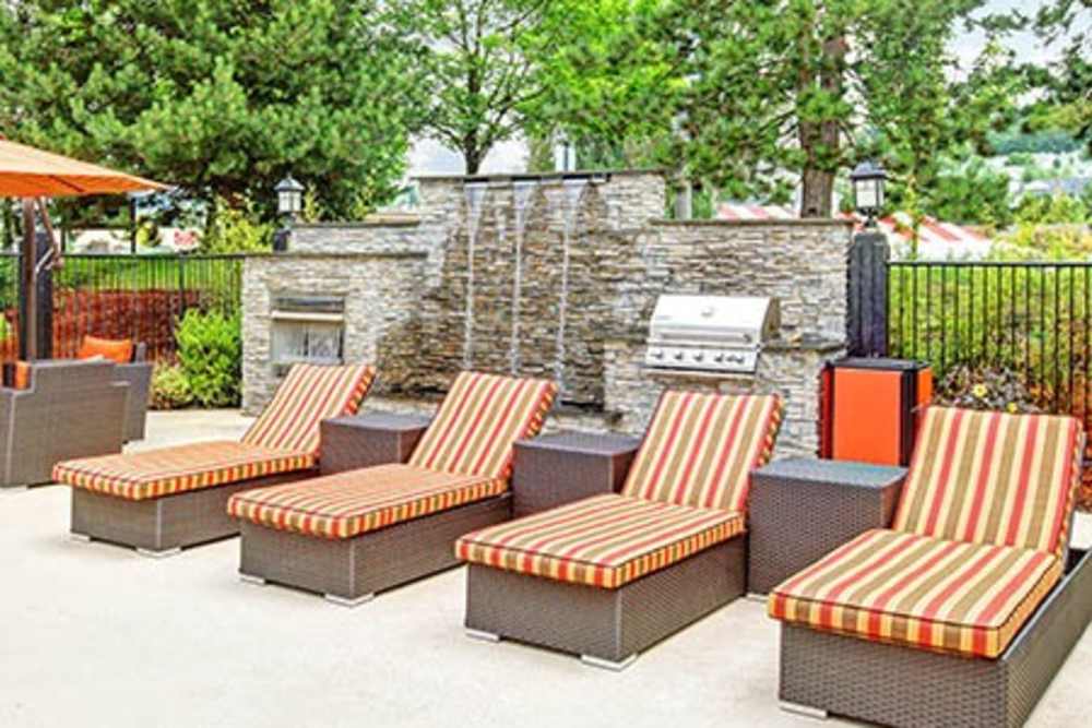 Barbecue amenities located next to the pool at Newport Crossing Apartments in Newcastle, Washington