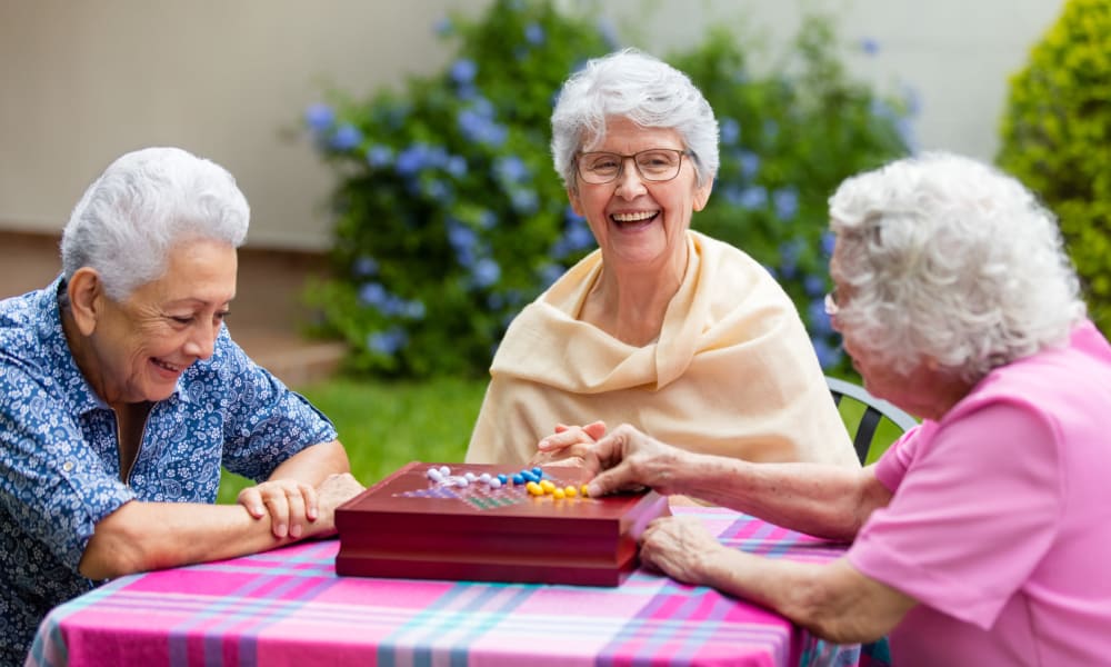 3 Residents playing Chinese checkers at Randall Residence in Lawton, Michigan