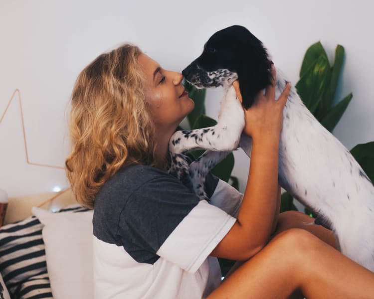 Resident giving her dog a kiss in their new home at Terra Martinez in Martinez, California