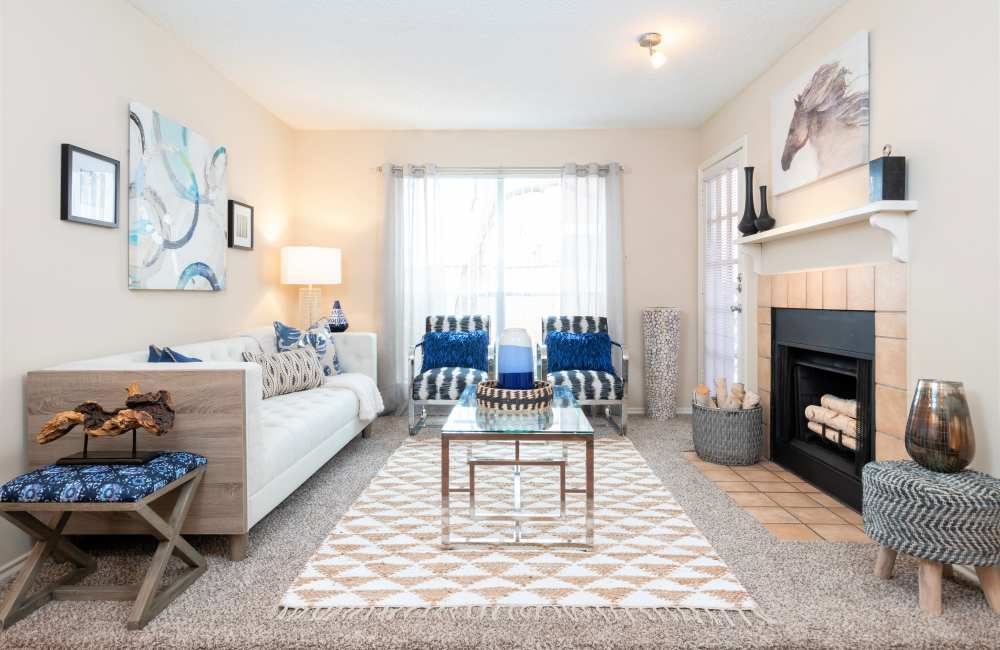 Charming living room featuring a cozy fireplace, modern decor, and natural light at Charter Oak in Euless, Texas.