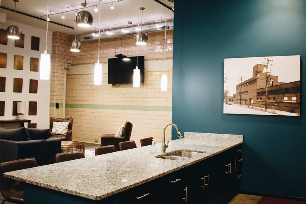 Modern kitchen with granite countertops and seating at Courtyard Lofts at Scott’s Addition in Richmond, Virginia